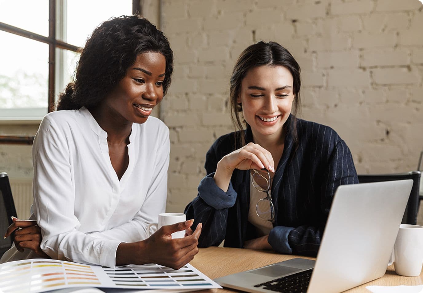 Two women working at a laptop